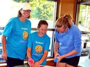 Jacquie Mohr (left), the coordinator of the breakfast/snack program at Mitchell District High School, and her daughters Stephanie and Sydney were decorating cookies all last week during Tim Hortons' annual Smile Cookie Campaign. All of the proceeds from selling smile cookies in Mitchell will go towards breakfast and snack programs at the high school and at Upper Thames Elementary School. GALEN SIMMONS/MITCHELL ADVOCATE