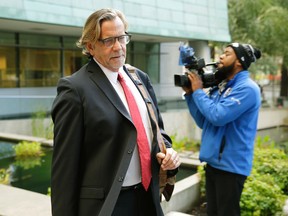 John Henry Browne, left, the attorney for Raymond Fryberg, the father of the Washington state teenager who fatally shot four classmates and himself at Marysville-Pilchuck High School in October, 2014, arrives at the federal courthouse in Seattle, Monday, Sept. 21, 2015. Fryberg is on trial this week for six counts of illegally possessing firearms, including the one used in the shooting, while under a domestic violence restraining order that meant he was not allowed to have guns. (AP Photo/Ted S. Warren)