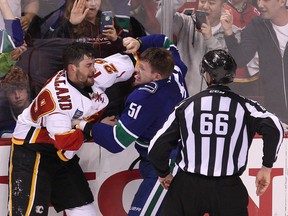 Flames' Deryk Engelland (left) and Canucks' Derek Dorsett (right) fight during the NHL playoffs in Vancouver on Friday, April 17, 2015. (Carmine Marinelli/Postmedia Network)