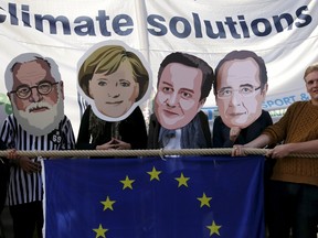 Environmental protesters wear masks depicting (L-R) European Climate Action and Energy Commissioner Miguel Arias Canete, German Chancellor Angela Merkel, Britain's Prime Minister David Cameron and French President Francois Hollande as activists stage a tug-of-war between polluting fossils fuels and renewable energy during a protest outside the European Union Council in Brussels, Belgium, September 18, 2015. EU environment ministers meet in Brussels on Friday to finalize the bloc's negotiating position for a U.N. climate summit in Paris starting at the end of November. REUTERS/Francois Lenoir