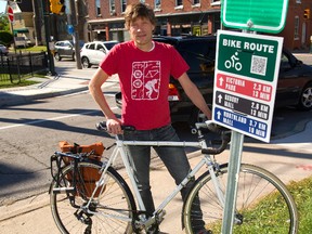 Tim Pearson, of CycleLink, shows off way-finding signs Monday his group has erected for cyclist in London. They replace decades-old, outdated bike route signs the city erected. (MIKE HENSEN, The London Free Press)