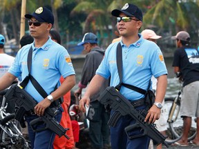 File photo of armed members of the Philippine National Police (PNP) patrol as they provide security during the Kadayawan festival in a downtown street of Davao city, southern Philippines August 20, 2011. REUTERS/Romeo Ranoco/Files