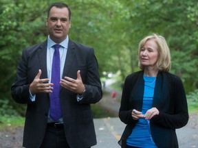 James Moore, left, speaks as Prime Minister Stephen Harper's wife Laureen Harper listens during a photo opportunity on the training route Terry Fox used while preparing for his cross-country run, in Port Moody, B.C., on Sept. 20, 2015. (THE CANADIAN PRESS/Darryl Dyck)