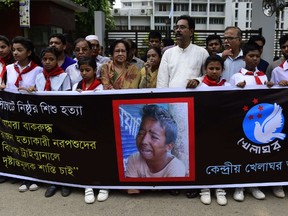 Bangladeshi protesters carry a banner during a demonstration against the lynching of a 13-year-old boy in Dhaka on July 14, 2015.  Outrage over the lynching of a 13-year-old boy mounted in Bangladesh July 14, 2015, with more protests over the murder which was captured on video, as one of the suspects confessed after being arrested in Saudi Arabia. On July 8, Samiul Islam Rajon was tied to a pole and then subjected to a sickening assault in which he pleaded for his life. The 28-minute video of Samiul, which went viral after being posted on social media, has sparked an outpouring of anger, with petitions and demonstrations demanding the attackers face the death penalty. AFP PHOTO/ Munir uz ZAMAN