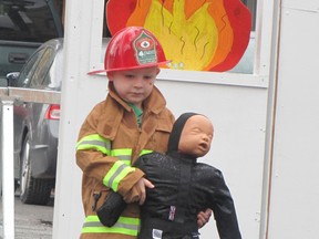 Colton Smulders, 4, of Chatham, carries a rescue doll to safety in the junior firefighter challenge at Chatham-Kent FireFest