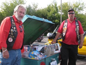 Ray Picard of Chatham, left, and Brian Ward of Kent Bridge pose beside a trailer filled with toys in the parking lot of the Salvation Army Citadel in Chatham. The items were collected during the 32nd annual toy ride organized by the Gold Wing Road Riders Association.