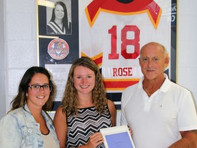 Lauren Rose, left, and Dan Rose, right, congratulate Davis Smith, this year's recipient of the Christie Rose PWHL Scholarship, presented annually to a Provincial Women’s Hockey League player.