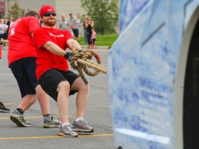 Luke Hendry/The Intelligencer
Dave Thebault strains to pull a bus with the Scotiabank team in Belleville Saturday. The Lung Association's 11th-annual Pull for Kids raised $10,632 to support lung health programs and research.