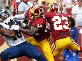 St. Louis Rams wide receiver Kenny Britt (18) catches a touchdown pass as Washington Redskins free safety Trenton Robinson (34) and Redskins cornerback DeAngelo Hall (23) defend in the third quarter at FedEx Field. The Redskins won 24-10. Geoff Burke-USA TODAY Sports