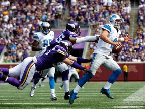 Lions quarterback Matthew Stafford (9) is pushed out of bounds by Vikings defensive end Brian Robison (96) and linebacker Anthony Barr (55) during NFL action in Minneapolis on Sunday, Sept. 20, 2015. (Jim Mone/AP Photo)