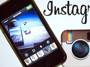 The Instagram logo is displayed next to a smartphone on Dec. 20, 2012 in Paris. (AFP PHOTO/LIONEL BONAVENTURE)