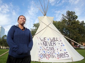 Lee-Anne Kent of Brokenhead First Nation stands outside a teepee on the grounds of the Manitoba Legislative Building In Winnipeg, Man. Tuesday September 22, 2015 to draw attention to the number of aboriginal children in care.