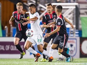 New York Cosmos forwarded Leonardo Fernandes is defended by, from left, Ottawa Fury's Richie Ryan Sinisa Ubiparipovic and Mauro Eustaquio as the team's met at James M. Shuart Stadium in New York on Tuesday, Sept. 22, 2015. (Gabrielle Dewey)
