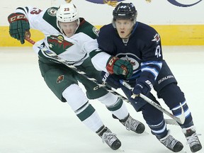 Minnesota Wild defenceman Gustav Olofsson (l) and Winnipeg Jets forward Nikolaj Ehlers fight for the puck during NHL hockey in Winnipeg, Man. Tuesday September 22, 2015.
Brian Donogh/Winnipeg Sun/Postmedia Network