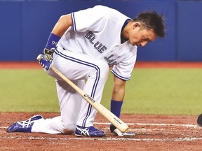 Blue Jays second baseman Munenori Kawasaki loses his helmet at the plate after taking a big swing during last night’s game. (CANADIAN PRESS)