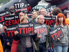 Protesters demonstrate against the Transatlantic Trade and Investment Partnership (TTIP) hold up signs reading "Stop TTIP" and "Stop CETA" in Germany. a similar protest is planned in Sudbury on Friday.
AFP PHOTO