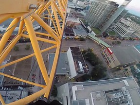 A man climbed a crane and dangled from it in a daring video posted on YouTube. (YOUTUBE SCREEN GRAB)
