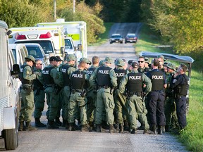 About two dozen police gather on Beck's Road at Kinburn Side Road Tuesday evening before leaving the area. The scene, which saw up to 30 police vehicles at one point, was where police arrested the Wilno shooting suspect earlier Tuesday afternoon.(DANI-ELLE DUBE/OTTAWA SUN)