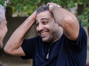 Canadian Al-Jazeera journalist Mohamed Fahmy reacts after being dropped off by authorities in the upmarket Cairo suburb of Maadi following his release from prison with his colleague Baher Mohamed after being pardoned by Egyptian President Abdel Fattah al-Sisi on September 23, 2015.(AFP PHOTO/STR)
