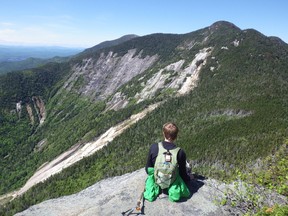 Submitted Photo
Kai Mackintosh takes a break with a view during a climb of Saddleback Mountain in the Adirondacks. Kai and his father, Blair, recently completed a five year challenge of climbing 46 mountains within the Adirondack range,