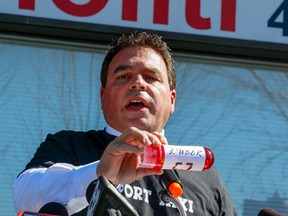 Toronto City Councillor Giorgio Mammoliti, speaks to a cab driver rally against Uber, holding a bottle of "Luber," on islington Ave. on Sept. 23, 2015. (Dave Thomas/Toronto Sun)