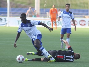 FC Edmonton defender Johann Smith takes off with the ball after knocking Ottawa Fury FC forward Oliver Minatel to the ground during NASL action in Fort McMurray Alta. on Sunday August 2, 2015. Robert Murray/Fort McMurray Today/Postmedia Network