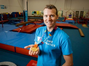 Kyle Shewfelt shows his Olympic gold medal at his gymnastics facility in southeast Calgary, Alta., on Thursday, Aug. 21, 2014.(Lyle Aspinall/Calgary Sun/QMI Agency)