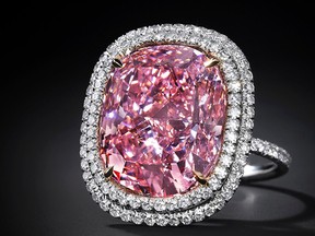 In this undated photo provided by Christie’s Auction House in New York, a 16.08 carat, a pink diamond the size of a postage stamp is shown in a ring setting. It could set a record for a cushion-shaped fancy vivid pink diamond when it’s offered Christie’s at its Magnificent Jewels sale in Geneva on Nov. 10, where it is estimated to bring as much as $28 million. (Antfarm Photography/Christie’s Auction House via AP)