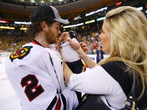 Chicago Blackhawks' Duncan Keith (L) holds his son Colton with his wife Kelly after the Blackhawks defeated the Boston Bruins in Game 6 of their NHL Stanley Cup Finals hockey series in Boston, Massachusetts, June 24, 2013. REUTERS/Brian Snyder