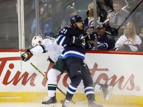 Winnipeg Jets  forward  Thomas Raffl (21) collides with Minnesota Wild defenceman Marco Scandella (6) during the second period at MTS Centre. Mandatory Credit: Bruce Fedyck-USA TODAY Sports