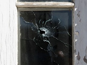 A bullet hole is visible in a front window of the Rochester Apartments, 10125 - 108 Street, following an early morning shooting, in Edmonton Alta. on Saturday Aug. 22, 2015. David Bloom/Edmonton Sun