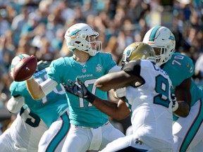 Miami Dolphins quarterback Ryan Tannehill (17) throws a pass as he is pressured by Jacksonville Jaguars defensive end Chris Clemons left, during the first half of an NFL football game in Jacksonville, Fla., Sunday, Sept. 20, 2015.(AP Photo/Phelan M. Ebenhack)