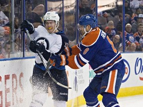 Winnipeg Jets' Andrew Copp (51) is checkd by Edmonton Oilers' Griffin Reinhart (8) during first period NHL pre-season action in Edmonton, Alta., on Wednesday September 23, 2015. THE CANADIAN PRESS/Jason Franson