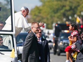 In this Sept. 23, 2015, photo, Pope Francis reaches to give a blessing to Sophie Cruz, 5, from suburban Los Angeles, during a parade in Washington. She also delivered a bright yellow T-shirt and a letter expressing wishes that her mother and father and millions of others who are in the U.S. illegally are allowed to remain in the country. A coalition of Los Angeles-based immigration rights groups pulled off a public-relations coup when a Cruz had a brief encounter with Pope Francis along a tightly controlled parade route.Cruz’s moment to deliver a message about the plight of immigrant parents living in the country illegally had been in the works for nearly a year.  (AP Photo/Alex Brandon, Pool)