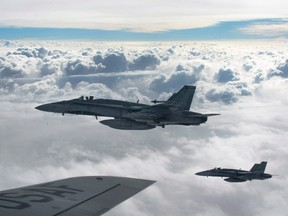 Royal Canadian Air Force CF-18 Hornets depart after refueling with a KC-135 Stratotanker assigned to the 340th Expeditionary Air Refueling Squadron, Thursday,  Oct. 30, 2014, over Iraq. 
.THE CANADIAN PRESS/HO-U.S. Air Force Photo by Staff Sgt. Perry Aston