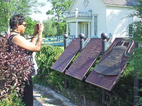 In this file photo from 2012, a visitor from Nova Scotia takes a photo of plaques at the Buxton National Historic Site and Museum.