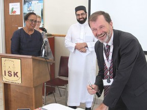 Steve Woodman, right, executive director of Family and Children's Services of Frontenac, Lennox and Addington, signs an agreement in Kingston, Ont. on Friday, Sept. 25, 2015 with the Islamic Society of Kingston, represented by Imam Sheharyar Shaikh, centre, and Kingston Community Health Centres, represented by executive director Hersh Sehdev, left, to provide better services to the city's immigrants. Michael Lea/The Whig-Standard/Postmedia Network