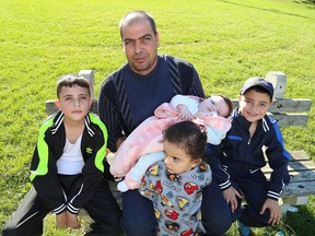 Members of the AlJalim family including father Marwan holding his daughter Masey, six months, Ouday, 9, Kousay, 8, and sister Roussey, 3, near their new home in Kingston on Friday after arriving from Syria via Lebanon earlier this year. (Ian MacAlpine/Whig-Standard file photo)