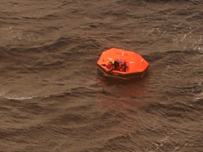 Survivors wave during initial contact with a CP-140 Aurora aircraft after abandoning their fishing vessel, the Atlantic Charger, southeast of Iqaluit on Sept.21, 2015. The owner of a Newfoundland fishing boat is praising his nine crew members and the rescuers who managed to bring them to safety from a life-raft that was being tossed in heaving seas off Baffin Island on Monday night. THE CANADIAN PRESS/HO-DND-Master Corporal Dianne Neuman
