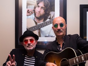 Andy Forgie (left) and Mark Rashotte pose in front of a framed photograph of John Lennon in the Empire Theatre lobby on Friday in Belleville. The pair will be celebrating Lennon's 75th birthday with a show titled In My Life . “They’re going to see a journey through the musical life of John Lennon,” said Forgie.
