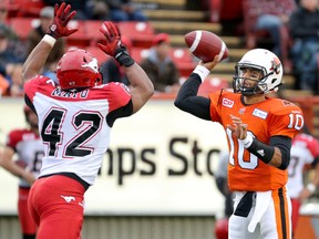 Calgary Stampeders Deron Mayo gets his hands up to try to block a pass by BC Lions Jonathon Jennings during pre-season CFL action at McMahon Stadium in Calgary, Alta.. on Friday June 12, 2015. Mike Drew/Calgary Sun/Postmedia Network