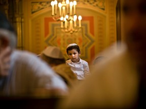 Jonah, 4, sits inside the Coral Temple, the main synagogue in Bucharest, Romania, Tuesday, Sept. 22, 2015 during a Yom Kippur religious service. Romanian Jews celebrate the Day of Atonement, Yom Kippur, the holiest day in the Jewish year which starts at sundown Tuesday. (AP Photo/Vadim Ghirda)