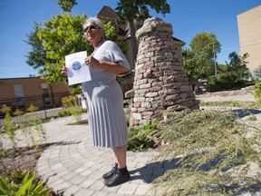 Reta Van Every, the native liaison for My Sisters' Place, stands beside a stone cairn, where decorated rocks are left in memory of women who have passed away, outside the women's shelter on Dundas Street in London, Ont. on Wednesday September 23, 2015. (CRAIG GLOVER, The London Free Press)
