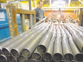 A worker grabs perforated steel pipes to be welded into a section of a bumper at the St. Thomas?s Formet plant. Local plants like Formet could feel the pinch from a Pacific Rim free-trade deal. (Free Press file photo)