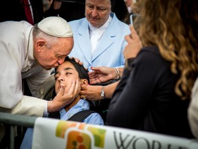 In this photo provided by World Meeting of Families, Pope Francis kisses and blesses Michael Keating, 10, of Elverson, Pa., after arriving in Philadelphia and exiting his car when he saw the boy, on Sept. 26, 2015, at Philadelphia International Airport. Keating has cerebral palsy and is the son of Chuck Keating, director of the Bishop Shanahan High School band that performed at Pope Francis' airport arrival. (Joseph Gidjunis/World Meeting of Families via AP)