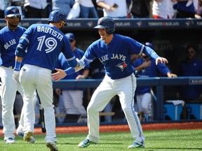 Blue Jays right fielder Jose Bautista (19) celebrates with third baseman Josh Donaldson (right) after hitting a three-run home run against the Rays in the first inning in Toronto on Saturday, Sept. 26, 2015. (Peter Llewellyn/USA TODAY Sports)