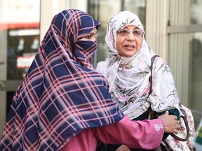 Zunera Ishaq (left) embraces her friend Nusrat Wahid after the Federal Court of Appeal overturned a ban on the wearing of niqabs at citizenship ceremonies, in Ottawa on Tuesday, Sept. 15, 2015. 
THE CANADIAN PRESS/Justin Tang