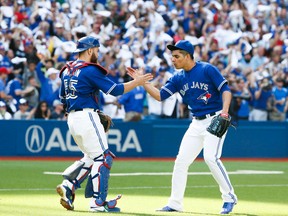 Blue Jays catcher Russell Martin (left) and pitcher Roberto Osuna (right) celebrate their win against Rays at the Rogers Centre in Toronto on Saturday, Sept. 26, 2015. (Stan Behal/Toronto Sun)