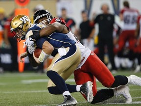 Matt Nichols gets hauled down during Friday's game. (KEVIN KING/Winnipeg Sun)