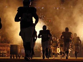 Members of the St. Louis Rams run on the field before an NFL football game against the Pittsburgh Steelers, Sunday, Sept. 27, 2015, in St. Louis. The game was delayed because part of the pyrotechnics used during the introductions briefly caught the turf on fire. (AP Photo/Billy Hurst)